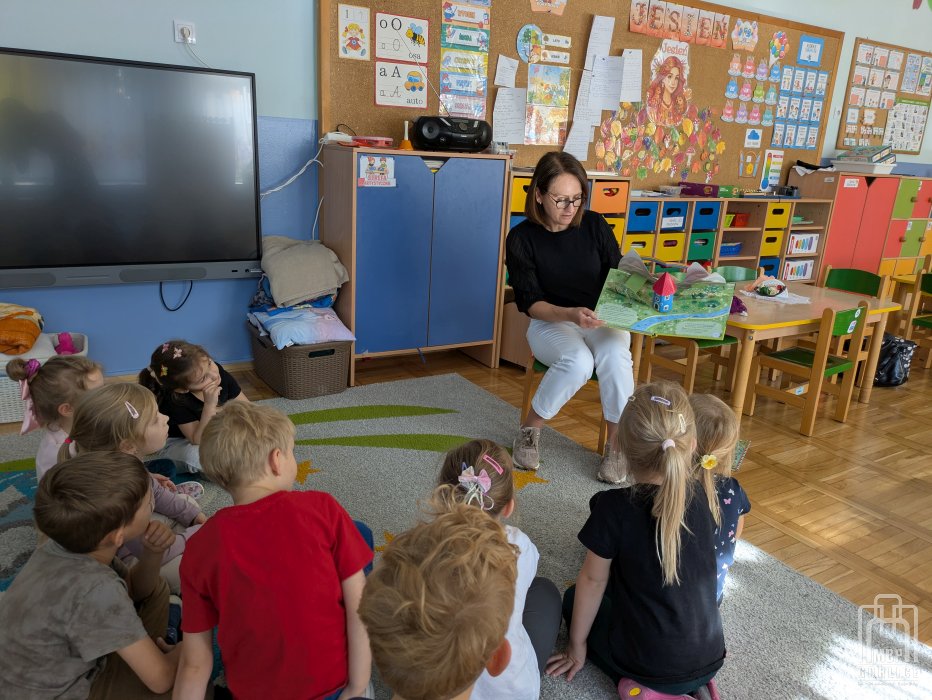 Biblioteka Gorlice, Cała Polska czyta dzieciom Bibliotekarka pokazuje dzieciom ksiązke o Muminkach.jpg